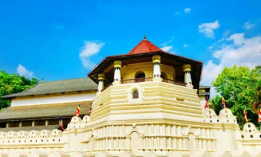 Sacred Temple of the Tooth Relic in Kandy, Sri Lanka, illuminated in the evening with traditional architecture.