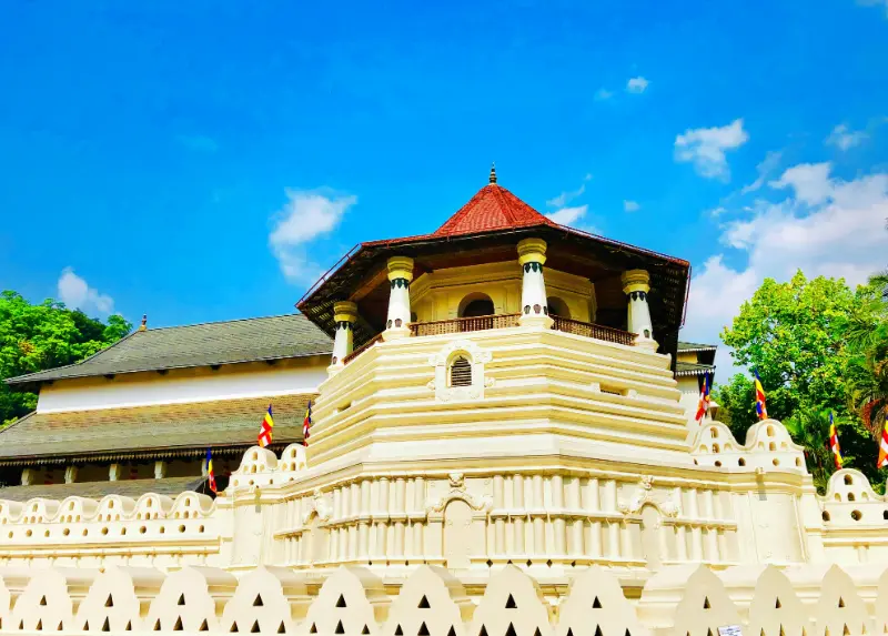 Sacred Temple of the Tooth Relic in Kandy, Sri Lanka, illuminated in the evening with traditional architecture.